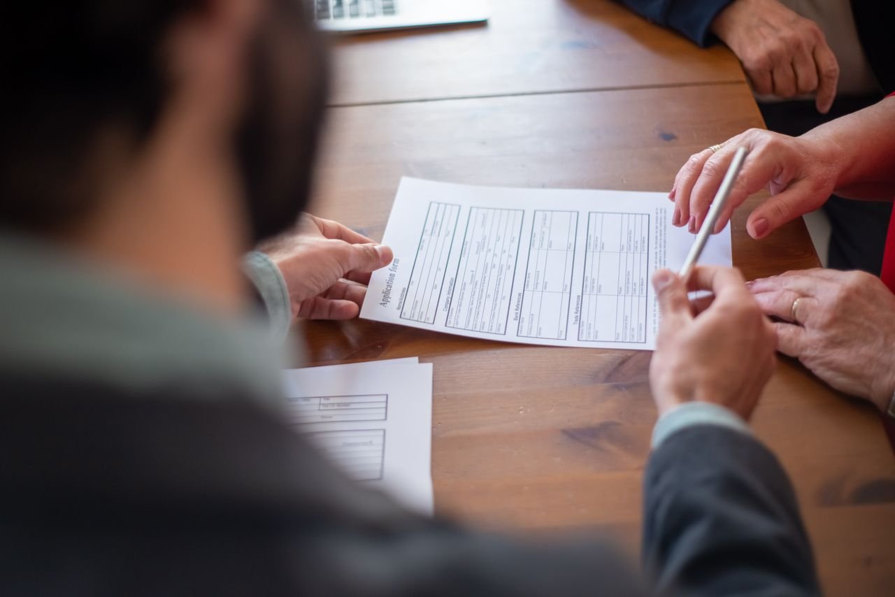 Close-up of business professionals reviewing documents at a meeting.